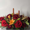 This arrangement is made with red roses, orange lily&rsquo;s, carnations and mix