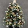 Christmas tree arrangement with gold roses and ornaments in a black box