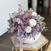 Lavender rose bouquet arranged in a white pumpkin vase
