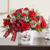 Red roses and carnations in a holiday tin with a plaid ribbon