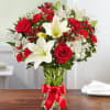 Red roses and white lilies in a glass vase with a red ribbon