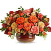 Orange roses and pink carnations in a brown glass vase