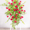 Tall arrangement of red roses on a white stand