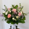 Pink and white mixed bouquet in a glass vase with a white ribbon
