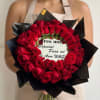 Heart-shaped bouquet of red roses with a printed message card