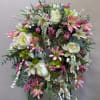 Large floral wreath with white and pink flowers and mixed greenery