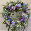 Purple and blue floral wreath with butterflies on a stand