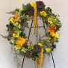 Large floral wreath with yellow and orange blooms on a stand