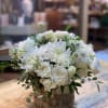 White roses and chrysanthemums arranged in a bark-covered container
