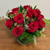 Red roses arranged in a green glass vase