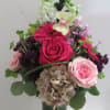 Mixed pink and white flowers arranged in a tall glass vase