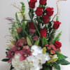 Red roses with white orchids and pink flowers in a rectangular container