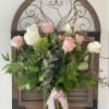 Pink and white roses in a glass vase with a pink ribbon
