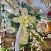 White floral standing spray with lilies and orchids on a ribboned easel