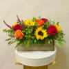 Bright mixed flower arrangement in a rectangular wooden box