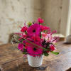 Bright pink mixed bouquet in a white ribbed pot