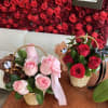 Two small rose baskets with teddy bears and ribbons on a table