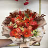 Bouquet of orange and pink flowers wrapped in beige paper