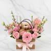 Pink flower basket with a teddy bear and ribbon