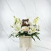 White floral arrangement with a small teddy bear in a Dior gift box
