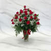 
Classic red roses with white fillers in a clear vase, tied with