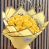Yellow rose bouquet wrapped in pale yellow paper with a satin ribbon