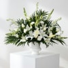White floral arrangement in a white pedestal vase