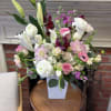 Mixed pink and white flower arrangement in a white vase