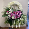 Large floral standing spray with pink and white roses and lilies on an easel