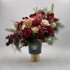 Red roses and pink orchids in a black vase with gold base