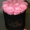 Pink roses arranged in a black round box