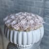 Pale pink roses arranged in a white ribbed vase