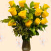 Yellow roses arranged in a dark glass vase