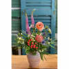 Mixed flower arrangement in a ceramic vase with pink and peach blooms