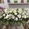 A serene and deeply respectful all-white floral tribute, this large-format arrangement is