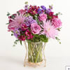 Pink and purple bouquet in a glass vase with a gold stand