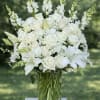 White roses and lilies arranged in a clear glass vase