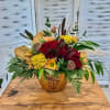 Mixed bouquet of red roses and yellow flowers in a decorative vase