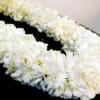 White floral lei on a dark surface