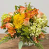 Orange and yellow mixed bouquet in a clear glass vase