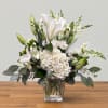 White lilies and hydrangeas in a clear square vase