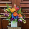 Colorful mixed flower arrangement in a white square vase