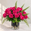 Pink rose bouquet in a clear glass vase with a black ribbon