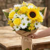 Bouquet of yellow roses, white daisies, and a sunflower wrapped in kraft paper