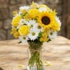 Yellow roses and white daisies in a clear glass vase