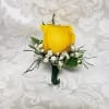 Yellow rose boutonniere with white filler flowers on a white background
