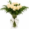 Cream roses arranged in a clear glass vase with a white ribbon