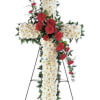 Standing floral cross with white and red flowers on an easel