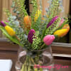 Colorful tulips arranged in a clear glass vase.