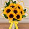 Bouquet of yellow sunflowers wrapped in white paper with a yellow ribbon
